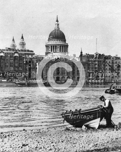 Thames waterman and his boat on the 'beach' at Bankside, London, 1926-1927. Artist: McLeish