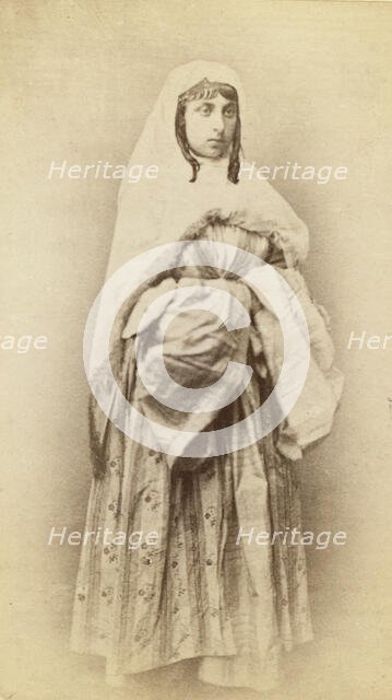 Full-length portrait of a woman, facing slightly right, in traditional dress, between 1870 and 1886. Creator: Unknown.