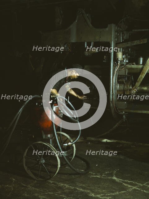 Thomas Madrigal greasing a locomotive in the roundhouse, Rock Island R.R., Blue Island, Ill., 1943. Creator: Jack Delano.