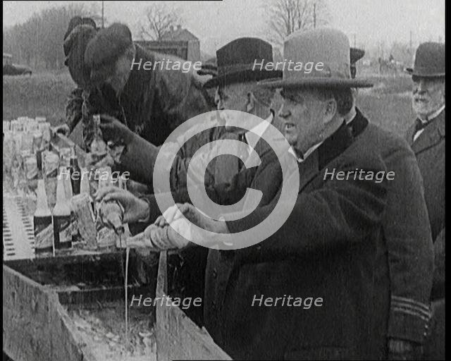 Prohibition Scenes in the United States of America. Men Pouring Away Bottles of Beer Into..., 1920. Creator: British Pathe Ltd.
