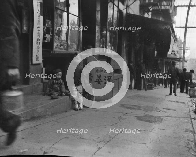 Three children in front of a cellar door, Chinatown, San Francisco, between 1896 and 1906. Creator: Arnold Genthe.