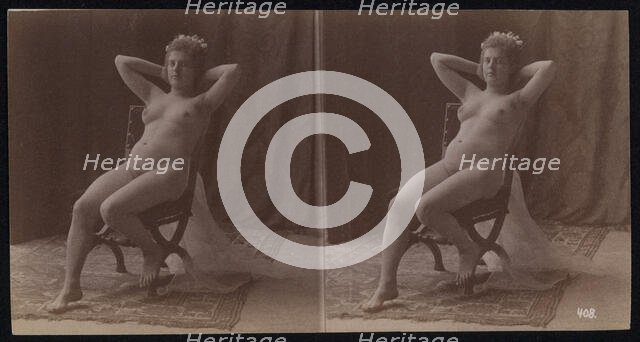 A young woman posing naked but for a long veil, leaning back in a chair, in a photographic..., c1900 Creator: Unknown.