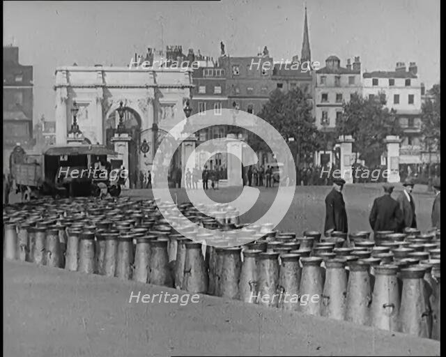 Milk Churns Lining the Street, 1926. Creator: British Pathe Ltd.