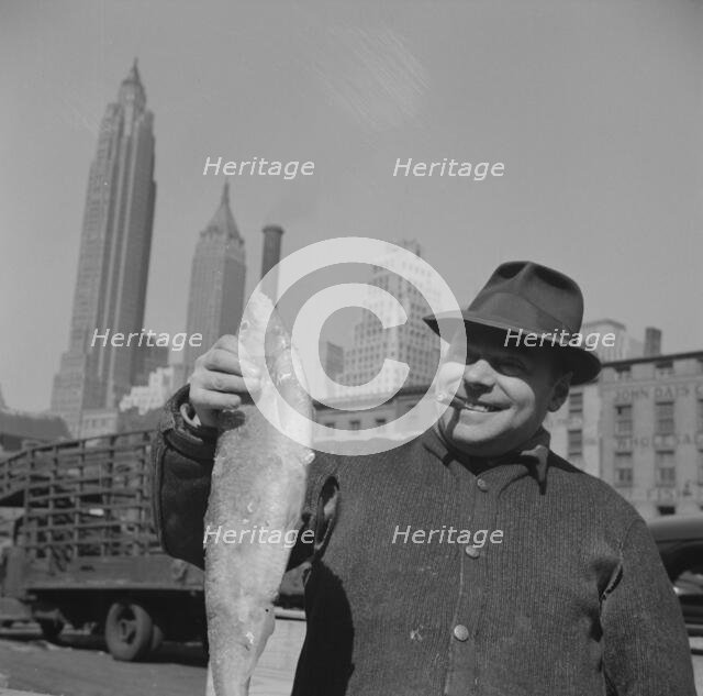 Fisherman holding a large catch at the Fulton fish market, New York, 1943. Creator: Gordon Parks.