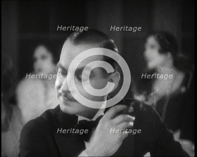 Scene from the Film 'Champagne': a Male Actor in a Nightclub Smoking a Cigarette, 1920s. Creator: British Pathe Ltd.