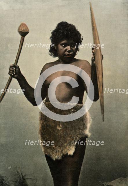 'Femme Australienne Chargee Des Armes De Son Mari', (Austrailan Woman with Husbands Weapons), 1900. Creator: Unknown.