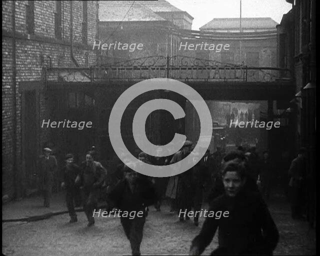 Crowd of Men Walking Through the Street Towards the Camera, 1933. Creator: British Pathe Ltd.