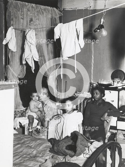 Negro family living in crowded quarters, Chicago, Illinois, April 1941. Creators: Farm Security Administration, Russell Lee.