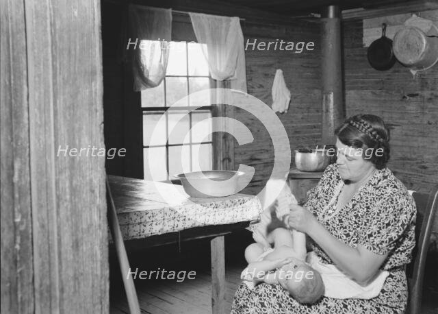 Wife of tobacco sharecropper bathing her baby..., Person County, North Carolina, 1939. Creator: Dorothea Lange.