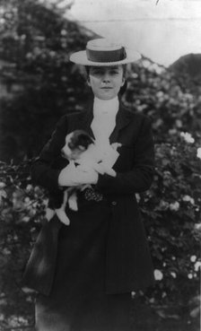Alice Roosevelt in riding clothes, with dog, c1902 June 17. Creator: Frances Benjamin Johnston.