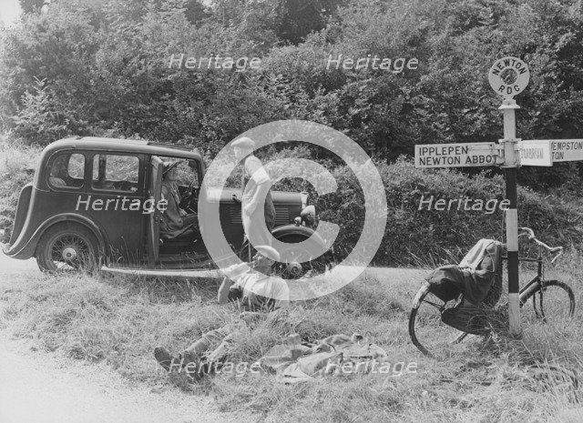 People relaxing by a signpost with a 1935 Standard 10 hp car, Devon, (c1935?). Artist: Unknown