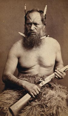 A Maori man with a tattoed face, holding a rifle, c1870s. Creator: James Bragge.