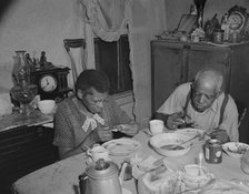 Elderly couple eating dinner at their home on Lamont Street, N.W., Washington, D.C., 1942. Creator: Gordon Parks.