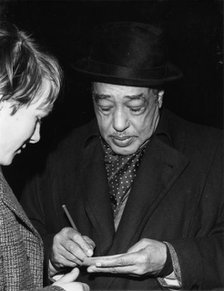 Duke Ellington signing his autograph, c1962. Creator: Brian Foskett.