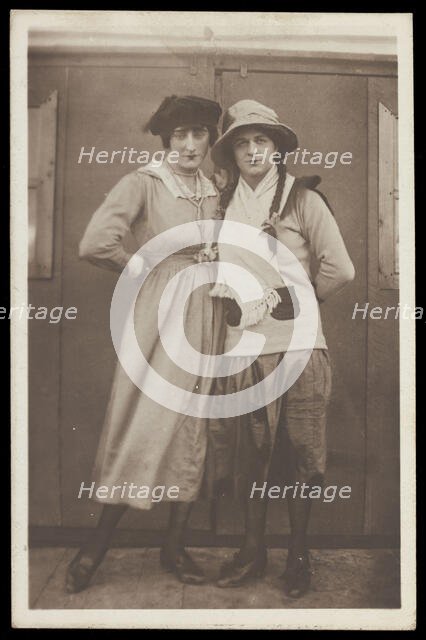 Two men, both in drag, pose wearing hats and make-up, c1918. Creator: Unknown.
