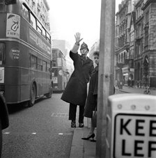 A policeman with his arm raised as two double decker buses pass by, City of London c1946-c1959. Artist: John Gay