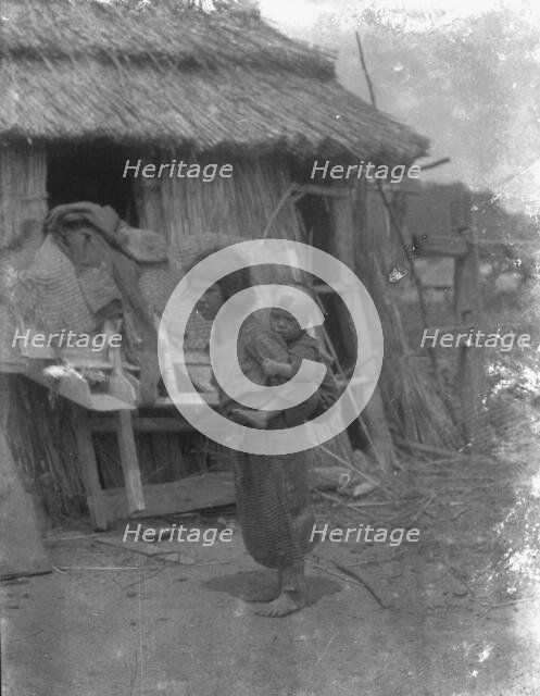 Ainu child carrying a baby on back, 1908. Creator: Arnold Genthe.