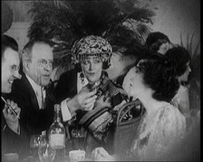 British Men and Women Sitting and Talking and Smoking at a Table in a Nightclub, 1922. Creator: British Pathe Ltd.