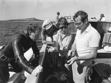 The Duke of Gloucester examines fragments of pottery brought up by a diver. Artist: Unknown