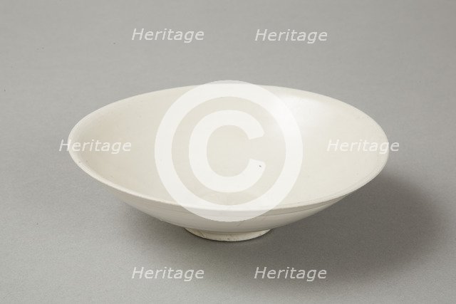 A shallow cream glazed bowl with rolled rim andraised footrim, Tang dynasty, c.800-900. Artist: Unknown.