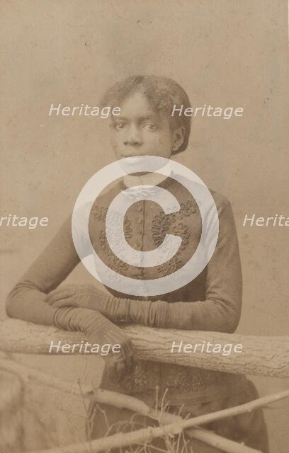 Unidentified young woman wearing gloves, leaning on prop fence, c1880. Creator: H. A. Insley.