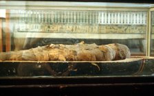 Mummy wrapped in bandages and lying on the base of a coffin, Ancient Egyptian. Artist: Unknown