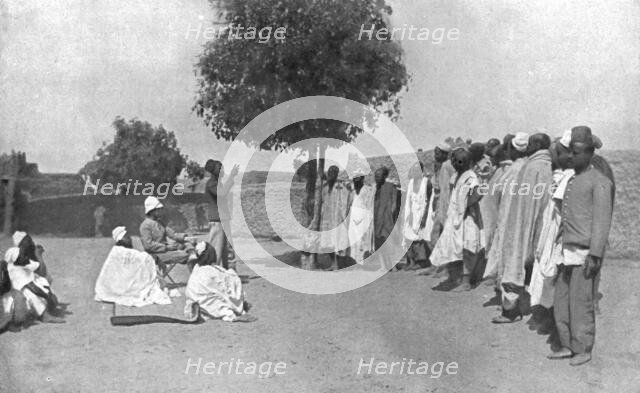 'Nos recrues de trois parties du monde; En Afrique occidentale: palabre aux recrues..., 1916 (1924) Creator: Unknown.