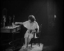 Female Civilian Dressing in Undergarments Seating in Front of a Dressing Table, 1920. Creator: British Pathe Ltd.