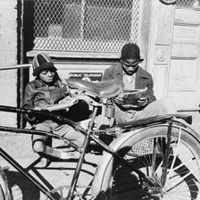 Two Negro boys reading the funnies on a doorstep, Washington, D.C., 1942. Creator: Gordon Parks.