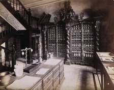 An eighteenth-century apothecary's shop with intricately carved wooden showcases; recreated.... Creator: Unknown.