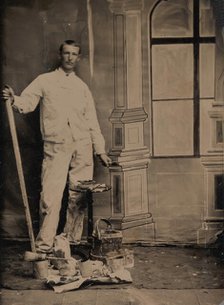 [Painter, Standing in Front of a Painted Window Backdrop, with Brushes, Bucket, and P..., 1870s-80s. Creator: Unknown.