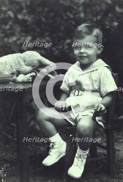 Portrait of a young boy seated at an outdoor table, facing front, between 1940 and 1950. Creator: Joseph Woodson Whitesell.