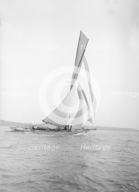 The 40-rater cutter 'Carina' sailing on a reach, 1911. Creator: Kirk & Sons of Cowes.