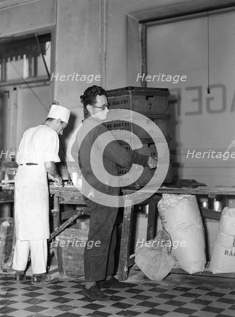 Delivery boy picking up bread  boxes at the Lisa Öhman Bakery, Stockholm, Sweden, 10th October 1942. Artist: Karl Sandels