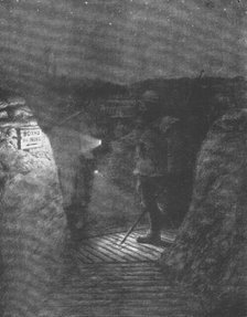 ''Une tournee d'inspectionnocturne dans les boyaux, a la lueur discrete des lampes de poche.', 1916. Creator: Unknown.