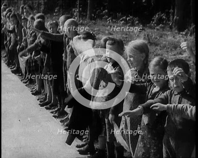 German Children Standing By the Side of a New Road, Some of Them Raising Their Arms in a..., 1937. Creator: British Pathe Ltd.