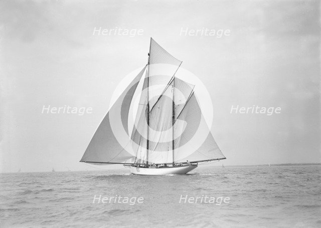 The 118 foot racing yacht 'Cariad' sailing with spinnaker, 1911. Creator: Kirk & Sons of Cowes.