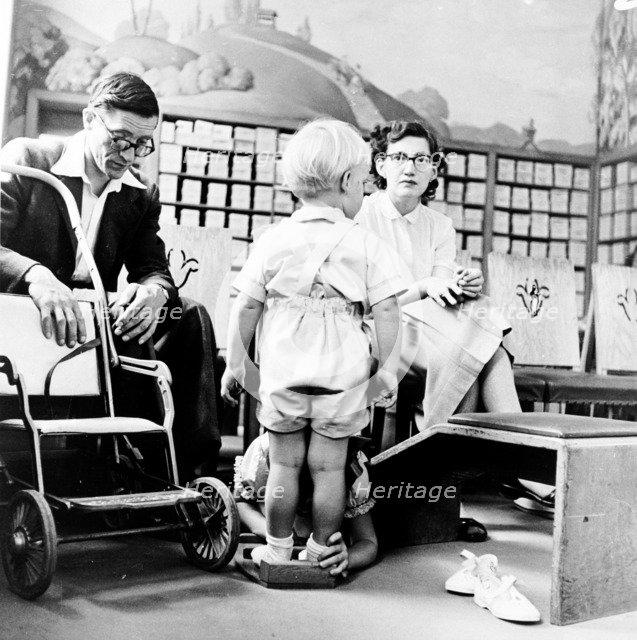 Child being fitted for new shoes in a London shoe shop, c1950s. Artist: Henry Grant