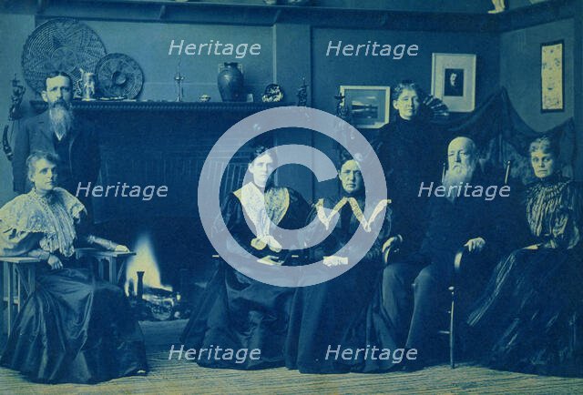 Frances Benjamin Johnston posed with six members of her family, by fireplace, in her Wash..., 1896. Creator: Frances Benjamin Johnston.