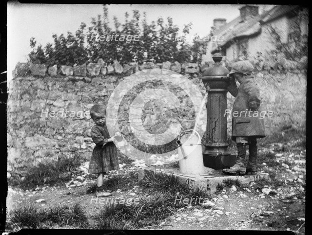 Two children collecting water at a water pump, Cheddar, Somerset, 1907. Creator: Katherine J Macfee.