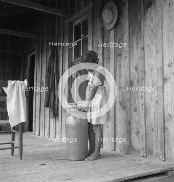 Pottery butter churn on porch of Negro tenant family, Randolph County, N Carolina, 1939. Creator: Dorothea Lange.