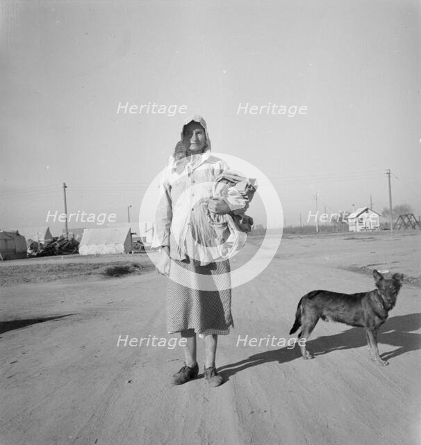 Cotton picker on her way to the cotton field, Kern migrant camp, California, 1936. Creator: Dorothea Lange.