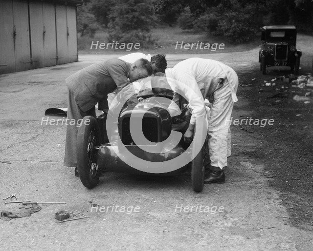 Mechanics working on Leon Cushman's Austin 7 racer for a speed record attempt, Brooklands, 1931. Artist: Bill Brunell.