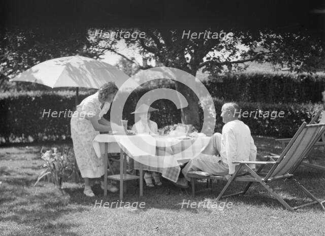 Leonard, Mr. and Mrs., eating outdoors, between 1926 and 1938. Creator: Arnold Genthe.
