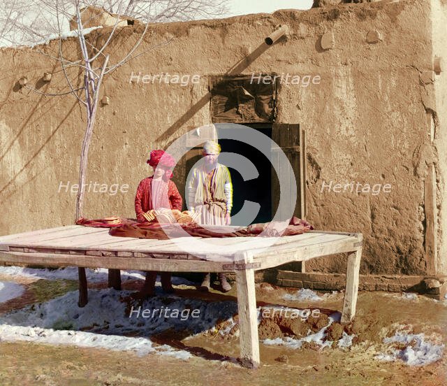 Vendors beside table displaying flatbread, between 1905 and 1915. Creator: Sergey Mikhaylovich Prokudin-Gorsky.