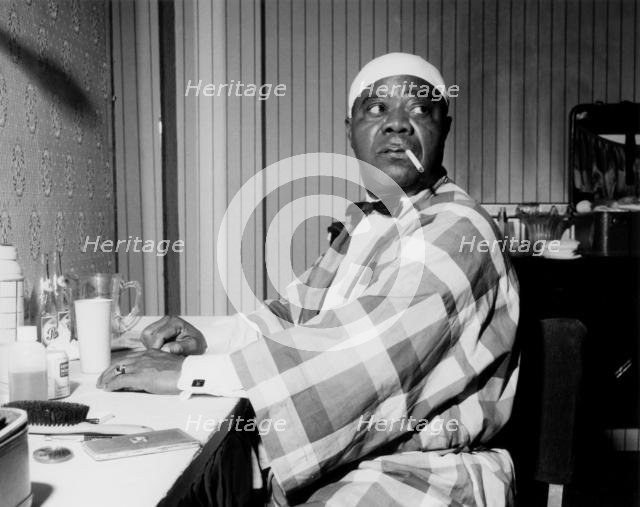 Louis Armstrong relaxing backstage, Finsbury Park Astoria, London, 1962. Creator: Brian Foskett.