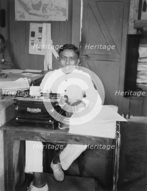 A young man sitting at a typewriter, Indonesia, 20th century. Artist: Unknown