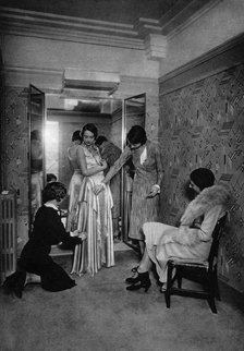 Trying on a dress at a great dressmakers, Paris, 1931.Artist: Ernest Flammarion