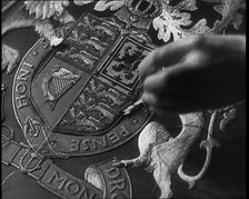 Hand of Seamstress Sewing a Royal Emblem, 1937. Creator: British Pathe Ltd.