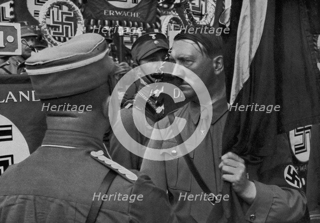 Adolf Hitler dedicating standards at the Nuremberg Rally, Germany, 1935. Artist: Unknown